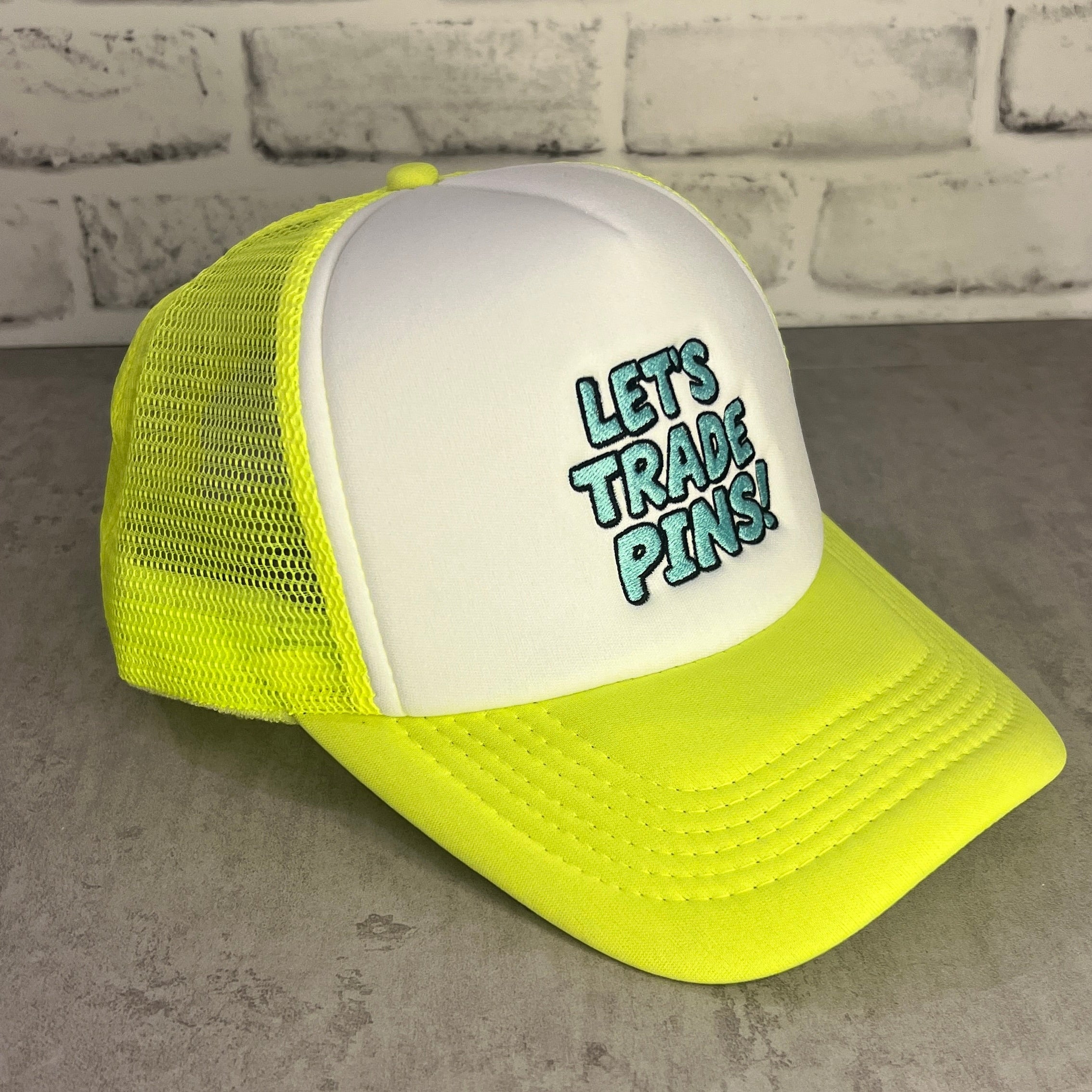 Neon Yellow and white trucker hat with 'Let's Trade Pins' text